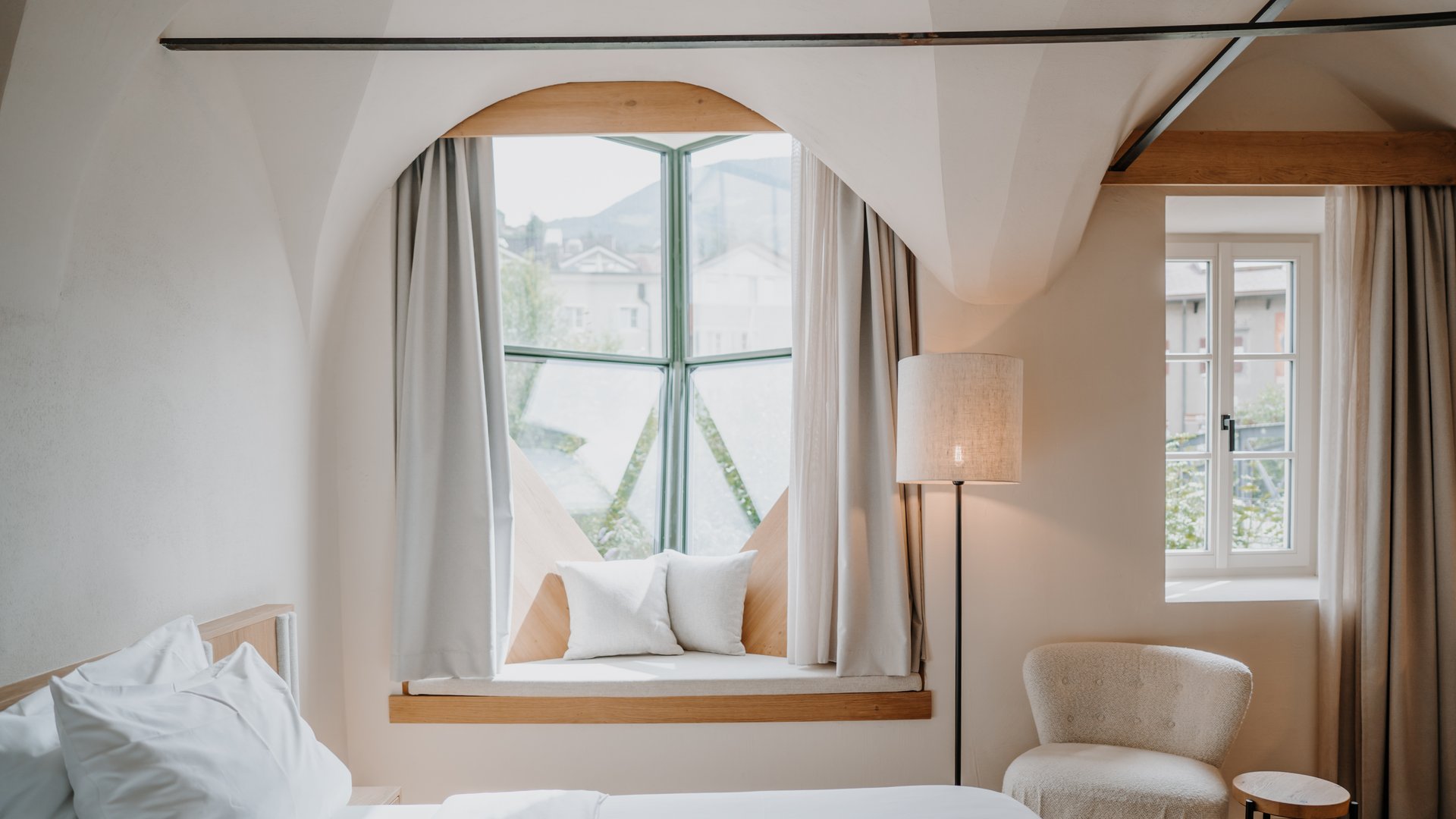 Camera luminosa con finestra imbottita e poltrona accogliente