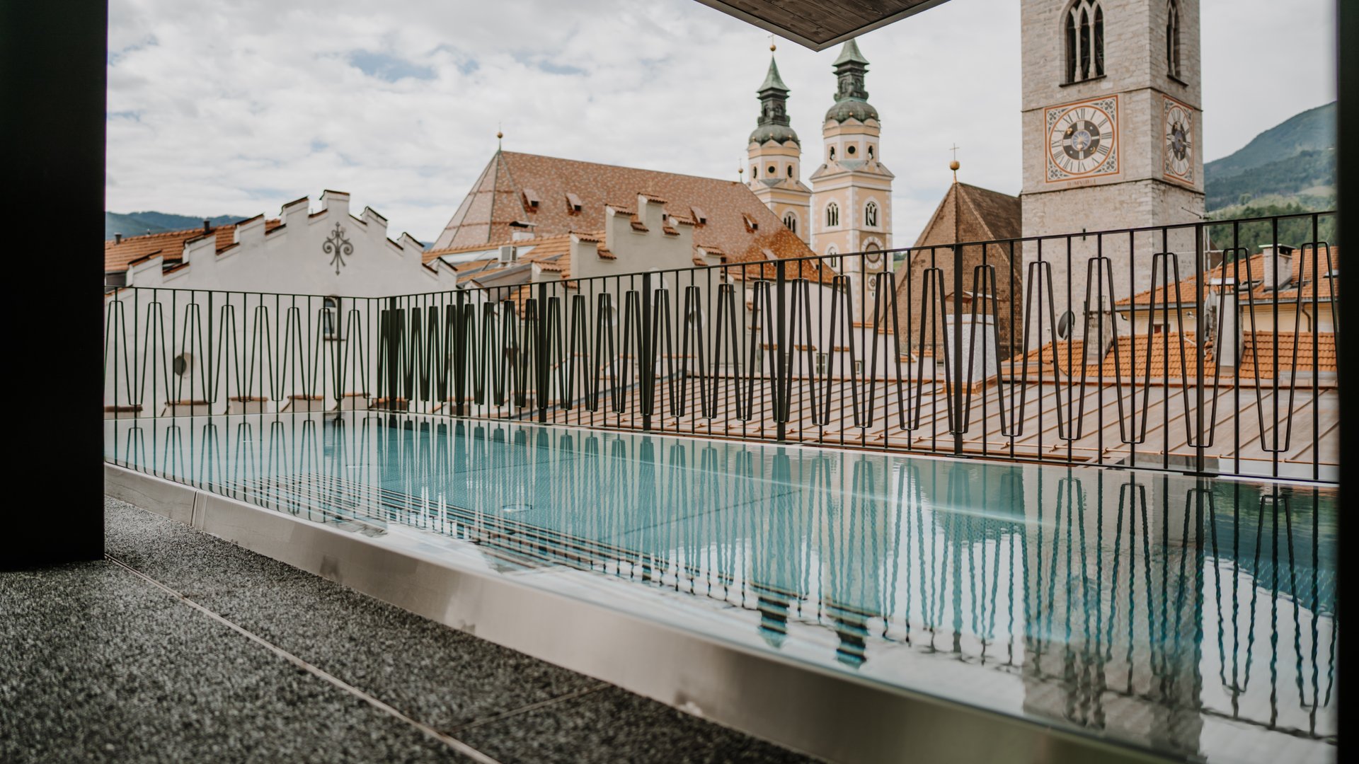Piscina sul balcone moderno con vista su torri di chiese storiche e tetti
