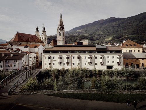 Vista della città con chiesa, fiume e montagne sullo sfondo