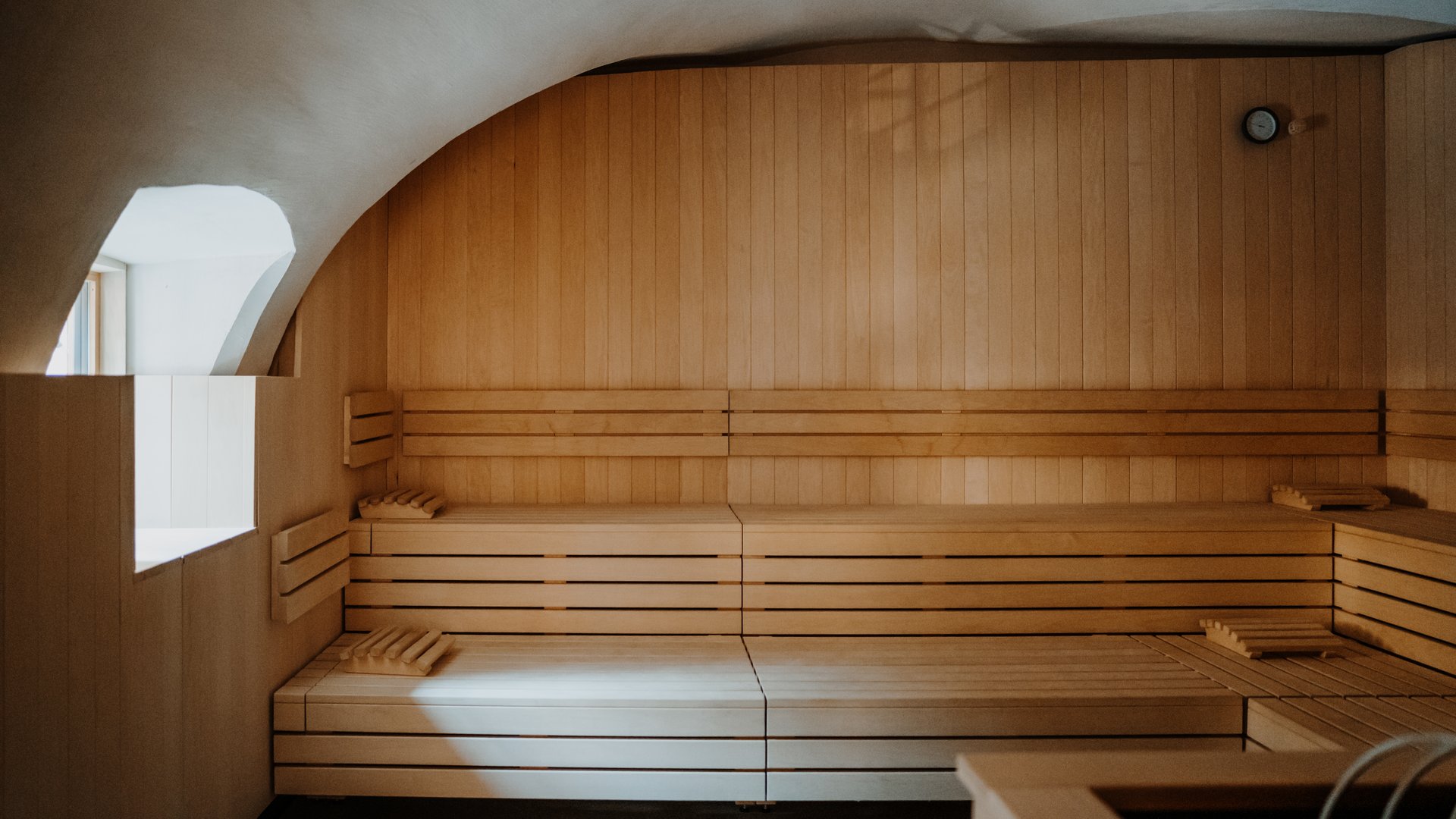 Interno sauna vuoto con panche di legno e luce dalla finestra